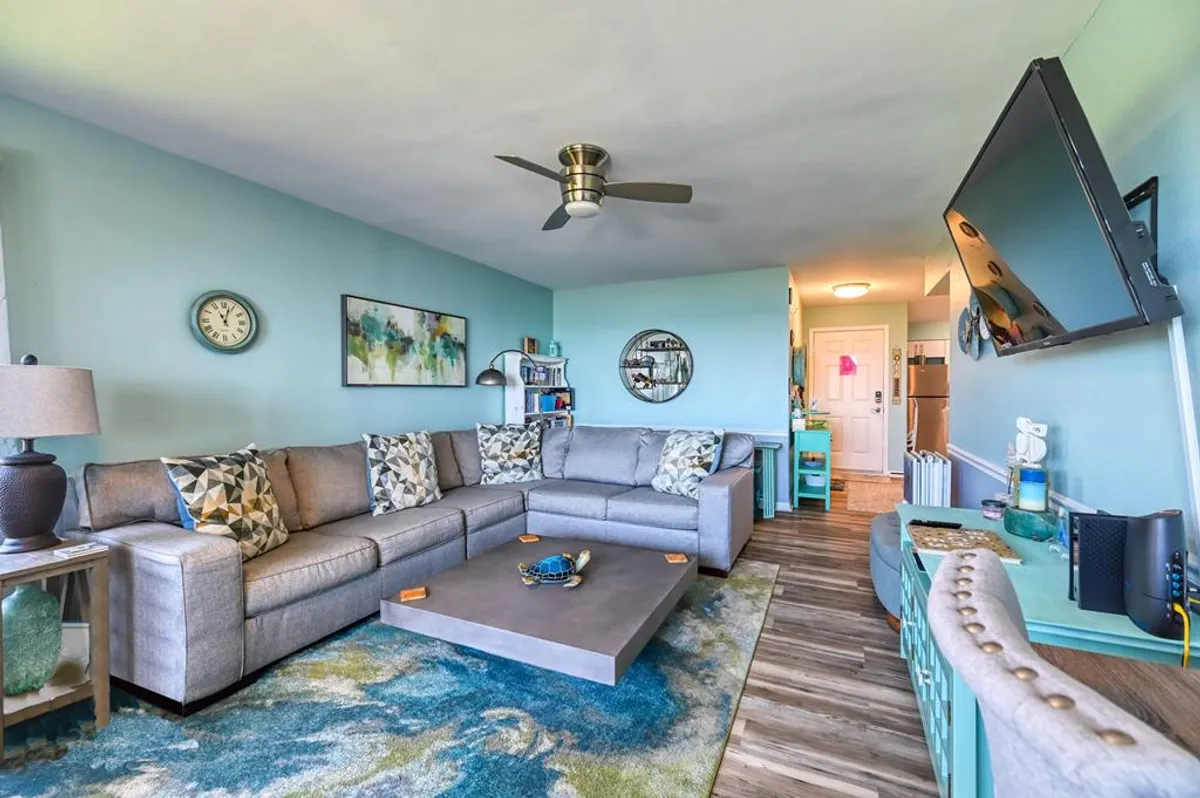 A comfortable living room with a plush sofa, coffee table, modern television, and inviting artwork. The space is arranged to encourage gatherings, conversations, and family time, embodying a welcoming atmosphere for evenings together.